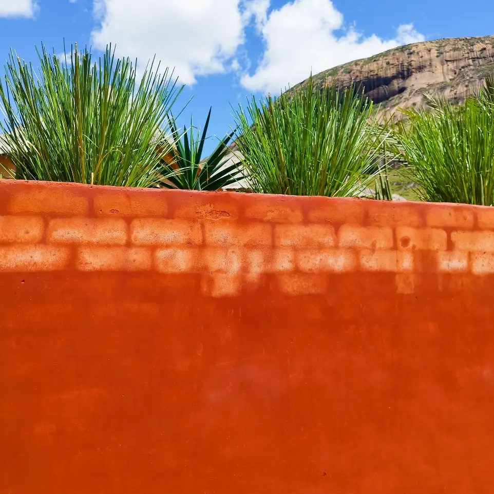 mur en laterite rouge du parking du restaurant