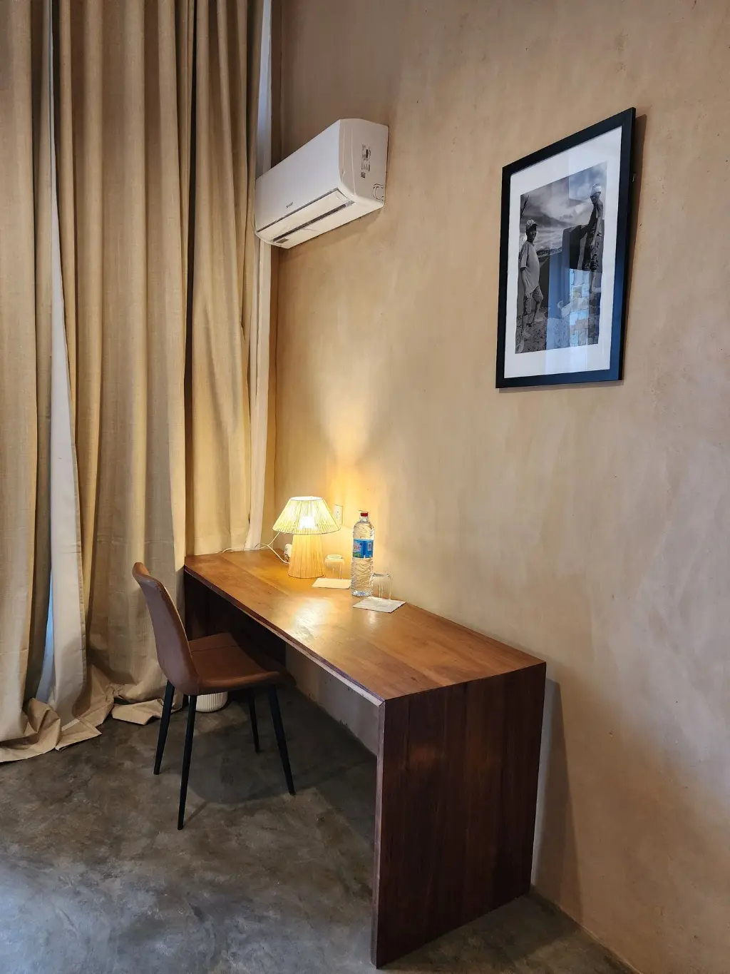 Espace bureau et confort moderne dans une Suite Signature à Anja. Bureau de travail dans une Suite Signature de The Anja Reserve Lodge à Ambalavao, avec climatisation, rideaux en lin, lampe en raphia et décoration inspirée de Madagascar près de la Réserve d’Anja.